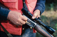 Photo du bras d'un chasseur tenant son arme